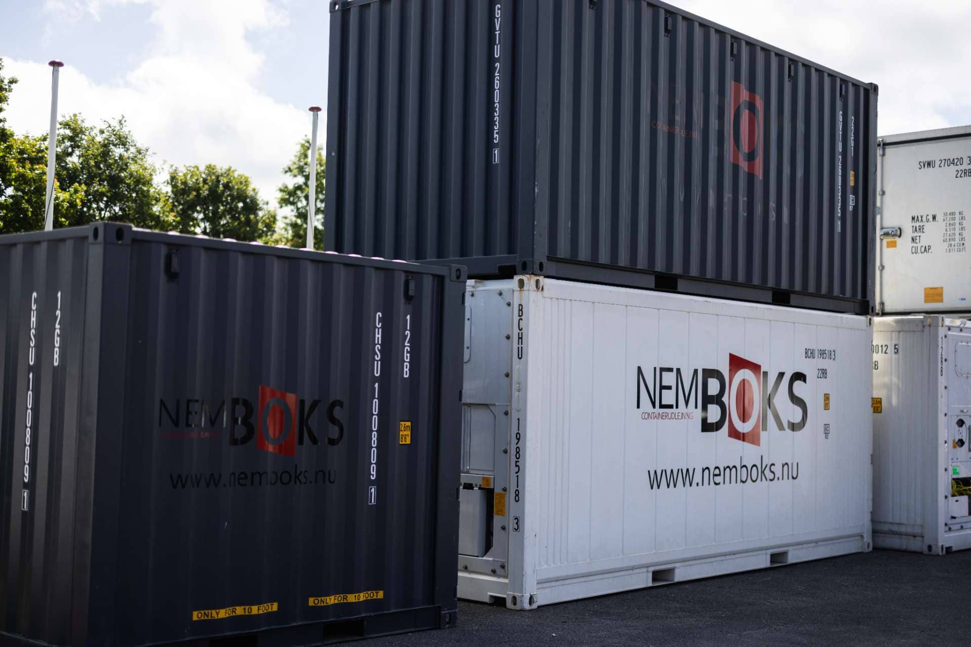 Mange containere med Nemboks logo i forskellige farver